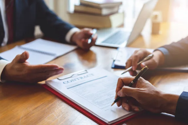 Business owners reviewing and signing transaction documents