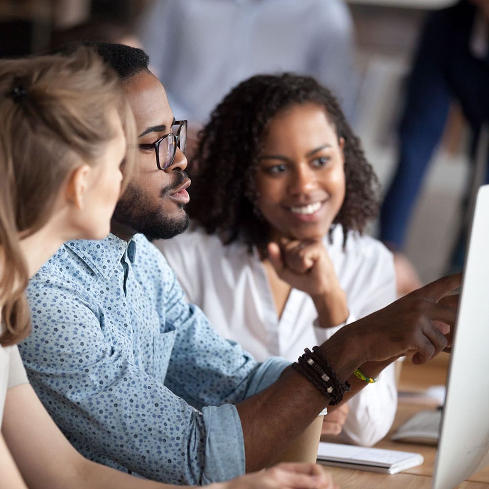 Founder collaborating with mentors around a computer